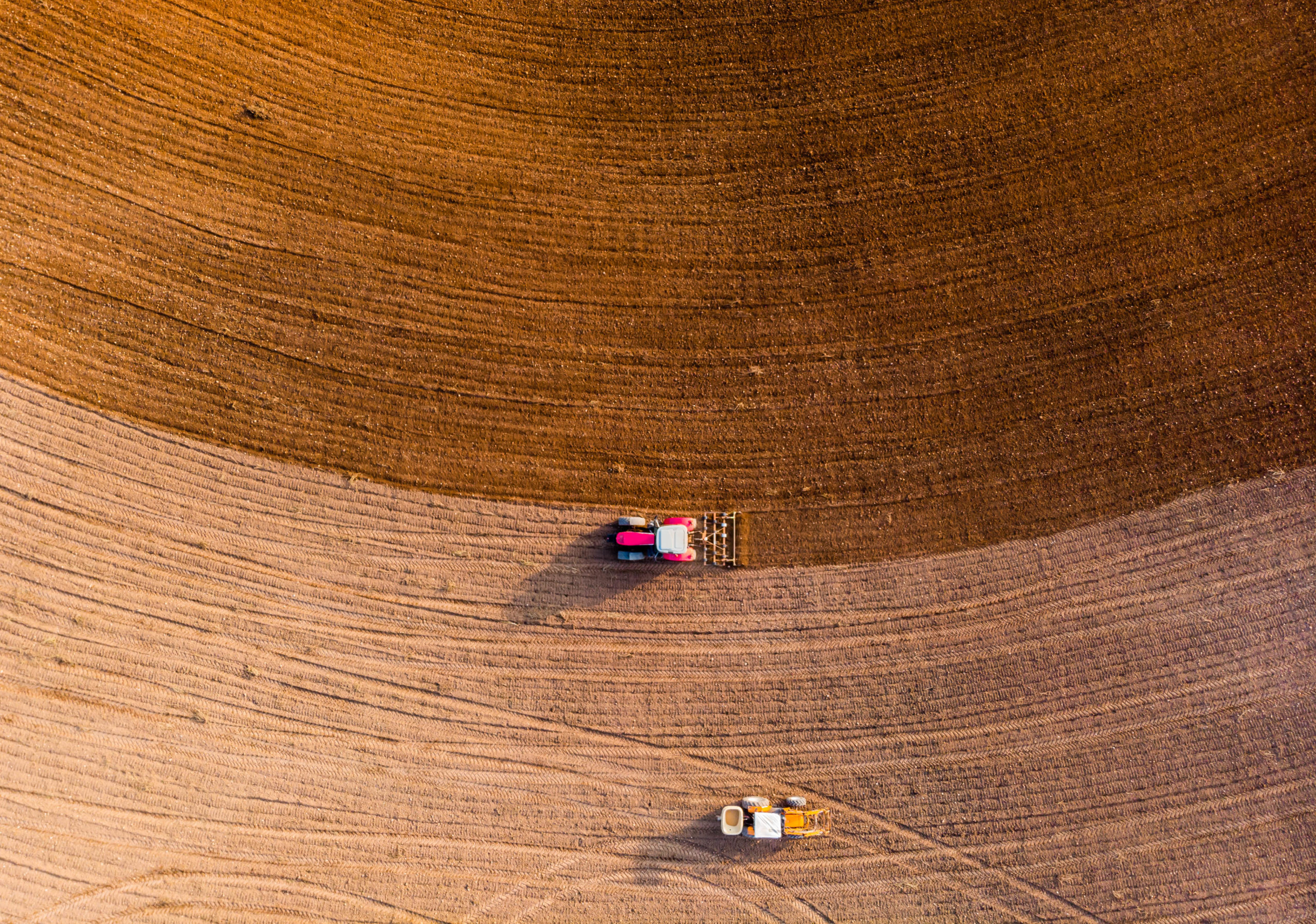 Aerial view with drone of tractor plowing the land in the countryside.